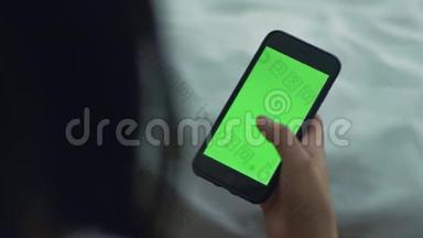 女人用绿色屏幕触摸智能<strong>手机</strong>。 女人手<strong>拿手机</strong>